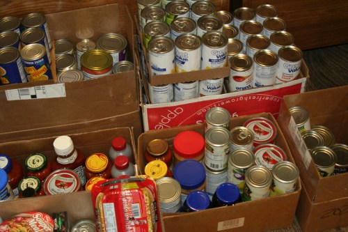 Boxes filled with various canned goods and condiments, organized for storage or distribution.