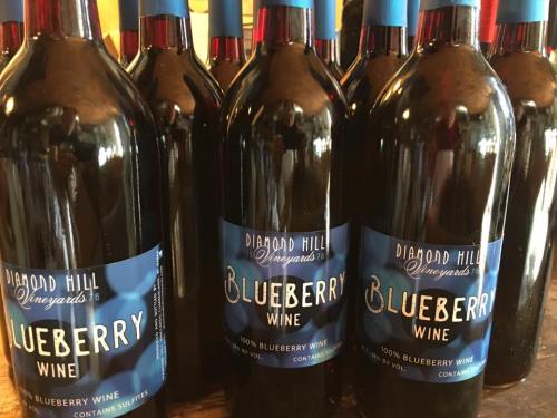 A collection of bottles of Diamond Hill Vineyards blueberry wine, labeled as 100% blueberry wine.