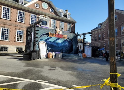 Stage setup for Salem Horror Fest, featuring a backdrop and decorations, with caution tape in the foreground.