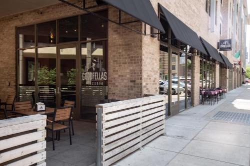 Exterior view of Goodfellas restaurant with outdoor seating and large windows, located on a city sidewalk.