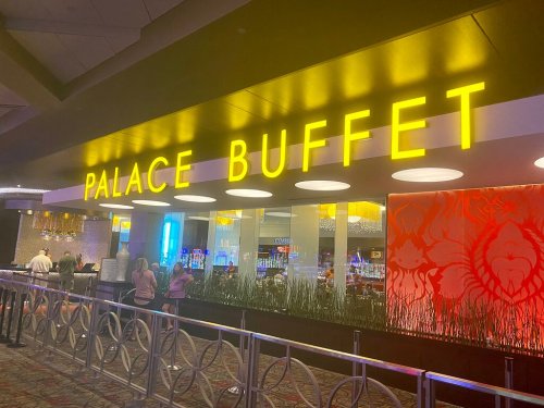Entrance to Palace Buffet with bright yellow signage and a modern interior design. People are waiting in line.