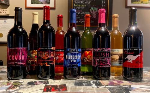 A collection of colorful wine bottles displayed on a table, featuring various labels and flavors.