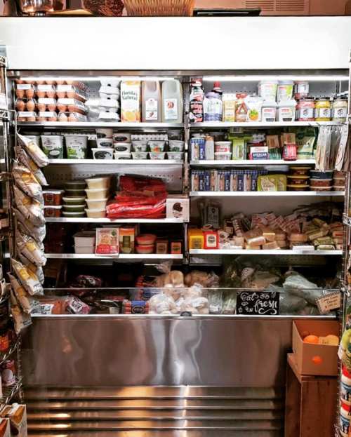 A well-stocked refrigerator displaying various food items, including dairy, condiments, and packaged meals.