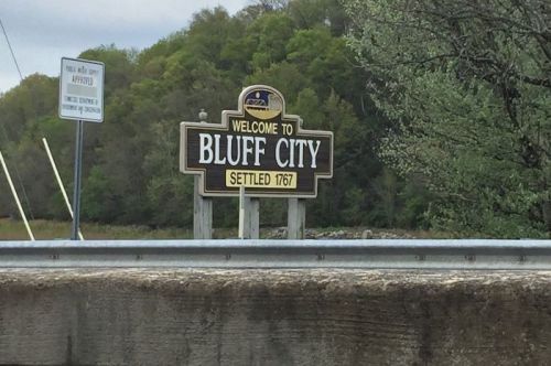 Welcome sign for Bluff City, established in 1767, with greenery in the background.