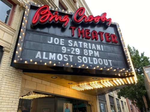 Marquee of Bing Crosby Theater announcing Joe Satriani concert on 9-29 at 8 PM, with "Almost Sold Out" displayed.