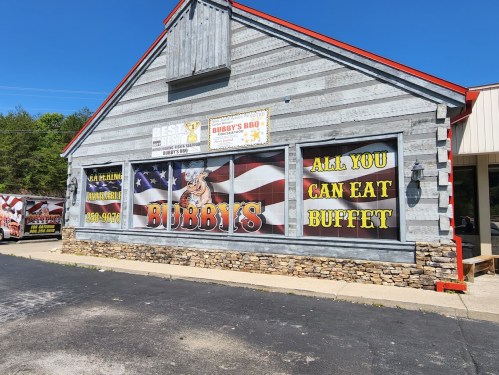 Exterior of Bubby's BBQ restaurant featuring a large sign for an all-you-can-eat buffet and American flags.