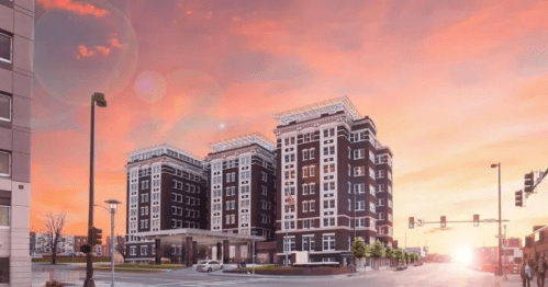 Modern hotel building at sunset, featuring a sleek design and vibrant sky with pink and orange hues.