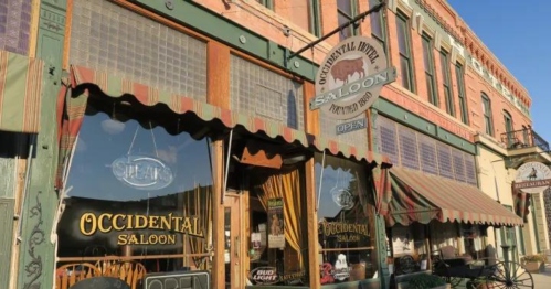 Exterior of the Occidental Saloon, featuring a vintage sign and colorful awnings, in a historic building.