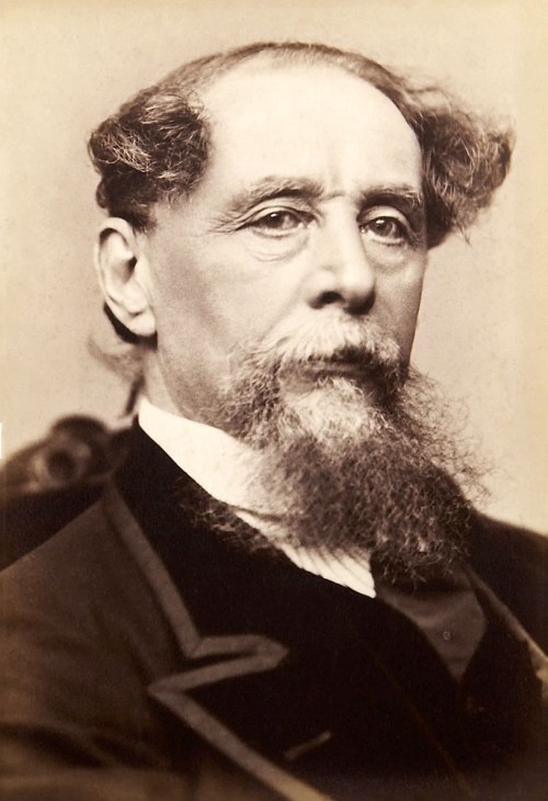 A vintage portrait of a man with a beard and distinctive hairstyle, wearing a formal suit.