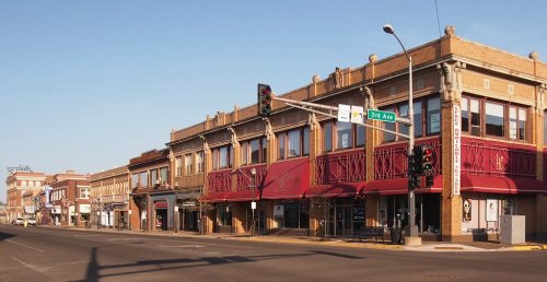 A street view of a historic downtown area with brick buildings and traffic lights on a clear day.