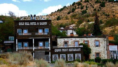 Historic buildings, including Gold Hill Hotel & Saloon and Crown Point Restaurant, set against a hilly landscape.