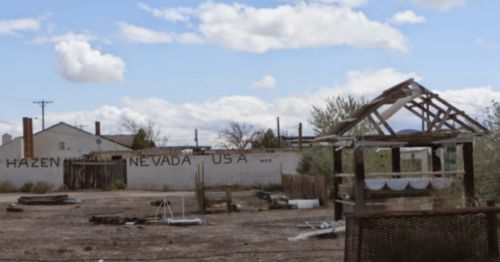 Abandoned buildings and structures in Hazen, Nevada, under a cloudy sky.