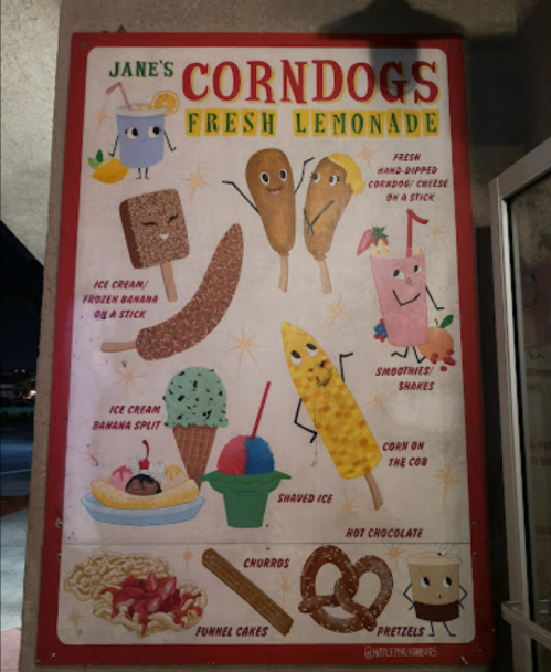 Colorful menu board featuring corndogs, lemonade, ice cream, and various snacks like churros and funnel cakes.