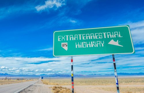 Sign for Extraterrestrial Highway in Nevada, with a clear blue sky and open road in the background.