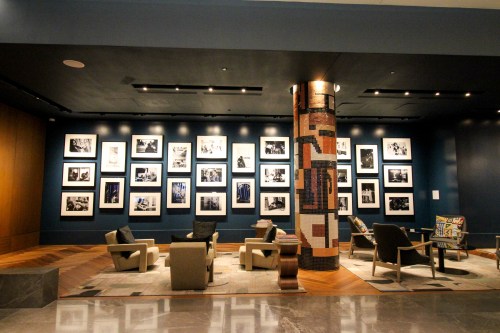 A modern gallery with black-and-white photos on the wall and comfortable seating in a stylish interior.