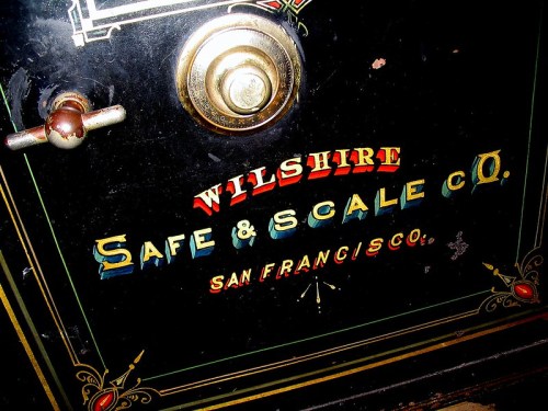 Close-up of a vintage safe door featuring the text "Wilshire Safe & Scale Co. San Francisco" in colorful lettering.