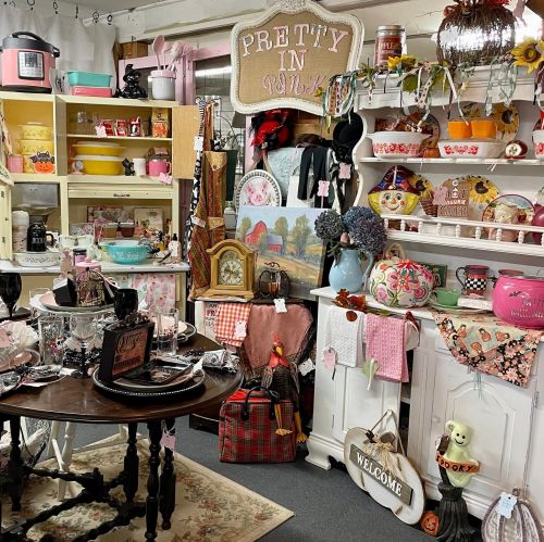 A cozy vintage shop display featuring colorful decor, kitchenware, and seasonal items on shelves and tables.