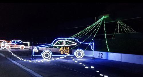 Colorful light display of race cars at night, featuring a prominent blue car with the number 48.
