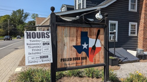 Sign for Pulled Fork BBQ with hours listed; open Tuesday to Saturday, closed Sunday and Monday. Texas-themed design.