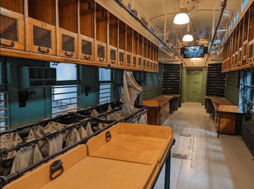 Interior of a spacious, well-lit room with wooden shelves and tables, featuring a clean, organized layout.