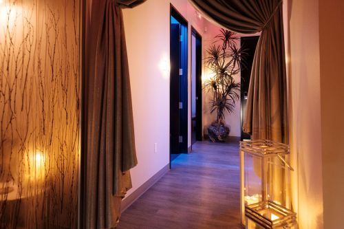 A softly lit hallway with curtains, plants, and decorative lanterns, creating a serene and inviting atmosphere.