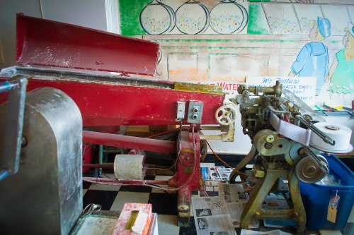 A vintage machine and equipment in a colorful, artistic setting, with newspapers scattered on the floor.