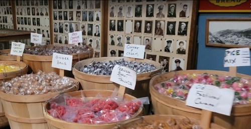 Baskets filled with colorful candies, surrounded by black-and-white photos on the wall.
