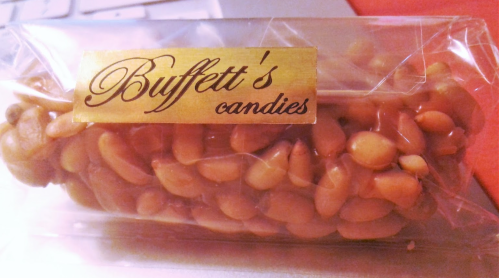 A clear package containing a candy bar with nuts, labeled "Buffett's candies."