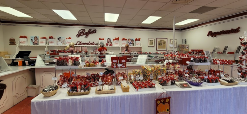 A cozy chocolate shop interior filled with various chocolates and treats displayed on counters and shelves.