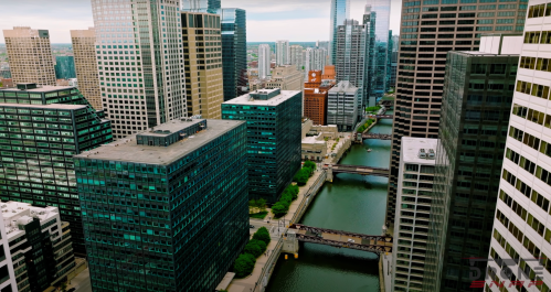 Aerial view of a city skyline with tall buildings and a river running through the urban landscape.