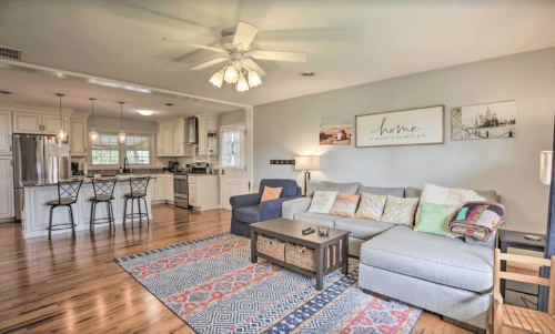 Cozy living room with a sectional sofa, coffee table, and open kitchen in a bright, inviting space.