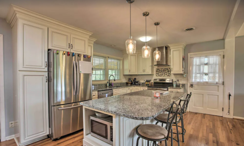 Modern kitchen with stainless steel appliances, granite countertops, and pendant lighting over a spacious island.