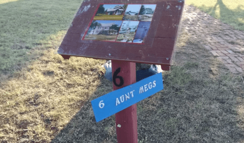 A wooden signpost with a blue plaque reading "6 AUNT MEGS" and a collage of images on a red background.