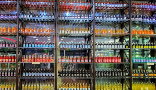 A colorful display of various soda bottles arranged neatly on shelves.