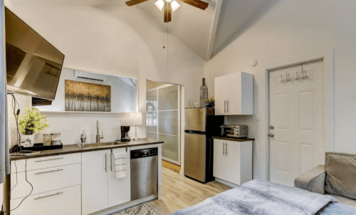 Cozy studio apartment with a kitchenette, modern appliances, and a comfortable seating area. Bright and inviting space.