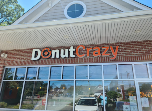 Exterior of a donut shop named "Donut Crazy," featuring a brick facade and large windows.