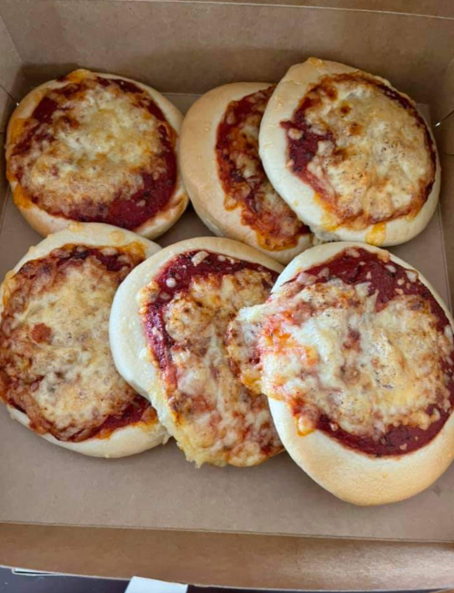 A box containing six mini pizzas topped with melted cheese and tomato sauce.
