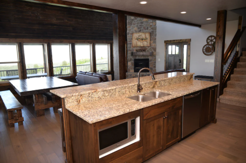Modern kitchen with granite countertops, stainless steel appliances, and a spacious dining area featuring large windows.