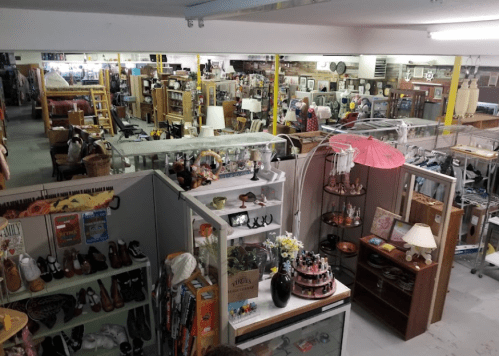 A spacious thrift store filled with various items, including furniture, decor, and clothing, viewed from above.