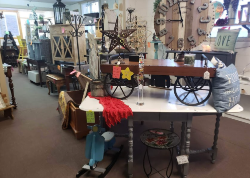 A cozy shop interior filled with vintage furniture, decor items, and colorful accessories on display.