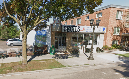 A restaurant named "Cecil's" with outdoor seating, located on a street with trees and nearby buildings.