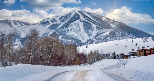 A snow-covered road leads to cabins and a ski hill in central Idaho.