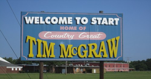 Sign welcoming visitors to Start, Louisiana, home of country artist Tim McGraw. Bright colors and clear text.