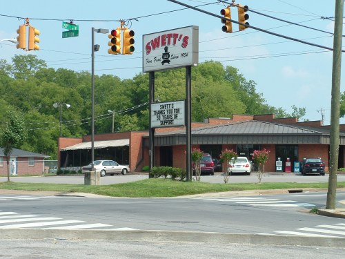 Sign for Swett's restaurant, thanking customers for 50 years of support, with a view of the building and surrounding area.