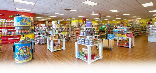 A colorful candy store interior filled with shelves of various sweets and snacks, featuring bright decor and displays.