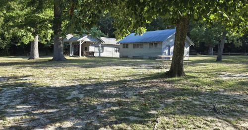 Views of two old buildings inside a wooded area in the town of Blackville, SC.