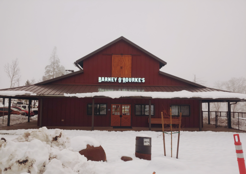 A red barn-style building with a sign reading "Barney O'Rourke's," surrounded by snow and a foggy atmosphere.