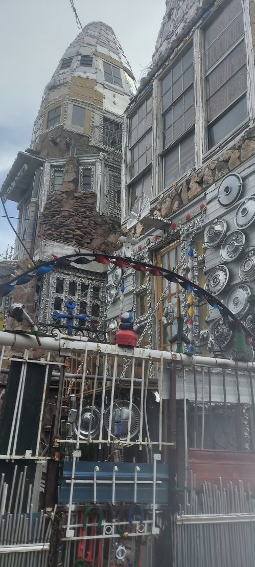 Colorful, eclectic building with unique architectural features, including metal decorations and various textures.