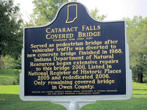 Sign about Cataract Falls Covered Bridge, detailing its history and repairs, located in Owen County, Indiana.