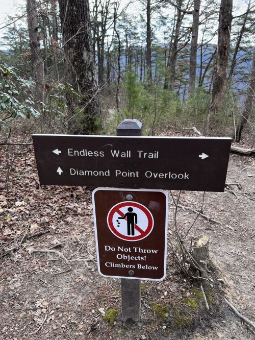 Trail sign indicating directions to Endless Wall Trail and Diamond Point Overlook, with a warning about throwing objects.